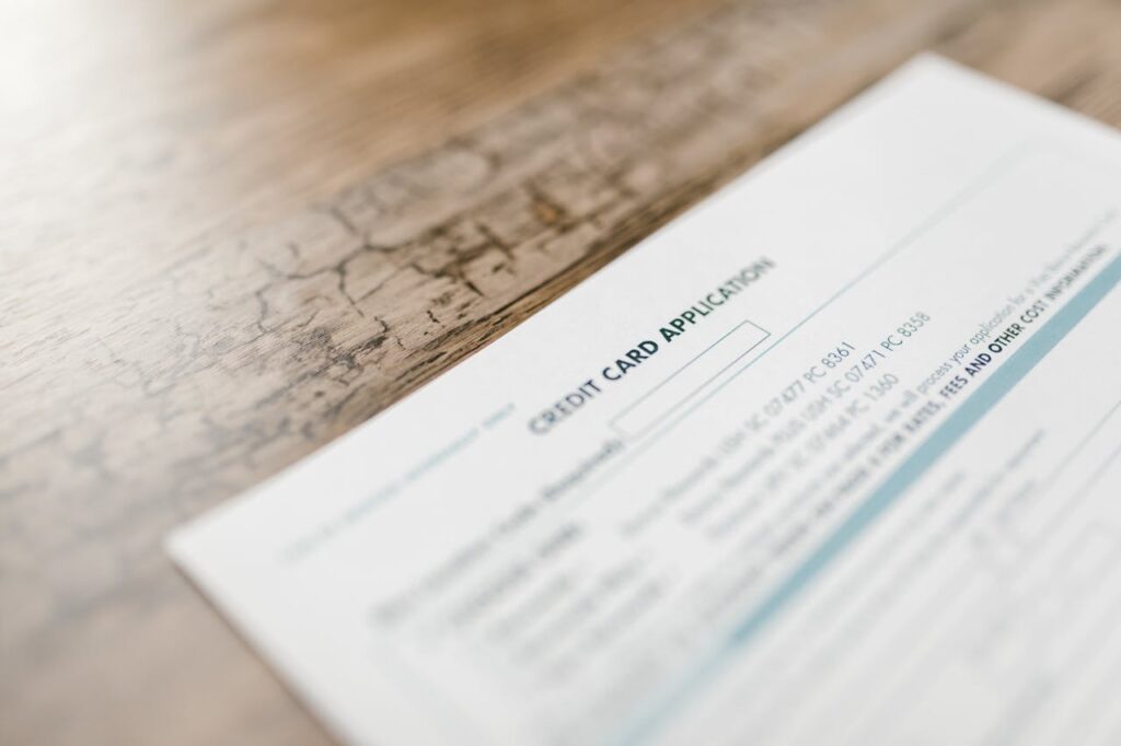 A credit card application on a wooden desk, depicting finance and banking tasks.